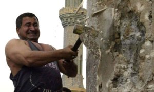 Kadom al-Jabouri swings a hammer at the base of the statue of Saddam Hussein in Baghdad in April 2003. Photograph: Jerome Delay/AP